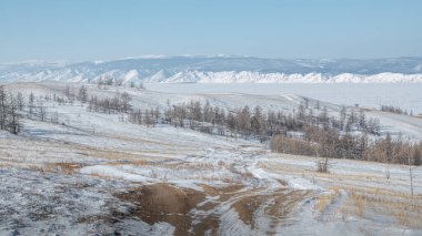 Kış yolu, Olkhon adasında ender bir ormanla kaplı tepelerle kaplı bozkırın içinden geçer..