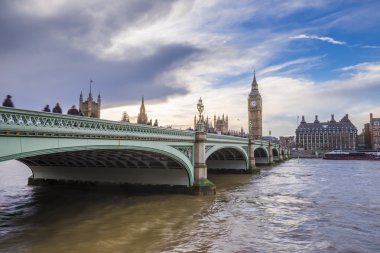 Westminster Bridge on a cloudy afternoon with tourists and Big Ben at the background - London, UK