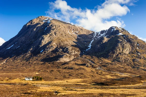 Detay mavi gökyüzü ile güneşli bir bahar gününde güzel bir beyaz yazlık ile Glencoe hakkında çekim - İskoçya, İngiltere — Stok fotoğraf