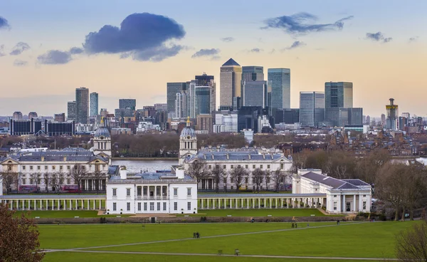 Skyline vista dei grattacieli di Canary Wharf e museo marittimo nazionale, girato dal parco di Greenwich al tramonto - Londra, Regno Unito — Foto Stock