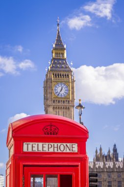 Güneşli bir öğleden sonra mavi gökyüzü ve bulutlar - Londra, İngiltere ile arka plan, Big Ben kutusuyla klasik kırmızı İngiliz telefon