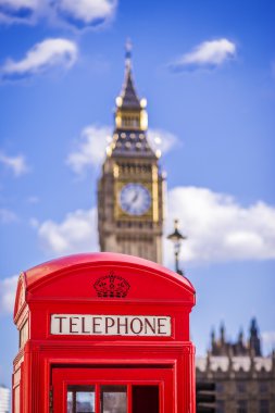 Güneşli bir öğleden sonra mavi gökyüzü ve bulutlar - Londra, İngiltere ile arka plan, Big Ben kutusuyla klasik kırmızı İngiliz telefon