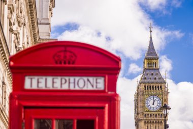 Güneşli bir öğleden sonra mavi gökyüzü ve bulutlar - Londra, İngiltere ile arka plan, Big Ben kutusuyla klasik kırmızı İngiliz telefon