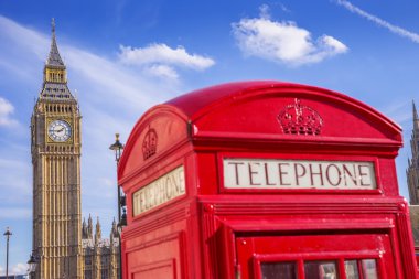 Güneşli bir öğleden sonra mavi gökyüzü - Londra, İngiltere ile Big Ben kutusuyla ikonik kırmızı İngiliz telefon