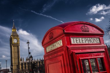 Big Ben kutusuyla dramatik gökyüzü ile geleneksel kırmızı İngiliz telefon