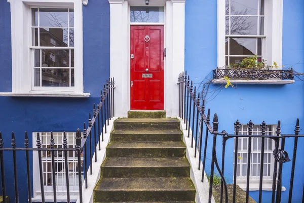 Entrée traditionnelle d'une maison peinte en bleu britannique avec porte rouge dans le quartier de Notting Hill près de la route Portobello - Londres, Royaume-Uni — Photo