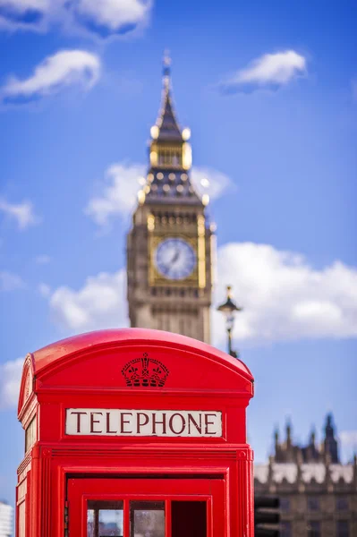 Classica cabina telefonica rossa britannica con il Big Ben sullo sfondo in un pomeriggio di sole con cielo blu e nuvole - Londra, Regno Unito — Foto Stock