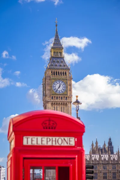 Класичний червоний британський телефон коробку з Біг-Бен в фоновому режимі у сонячний день з Синє небо та хмари - Лондон, Великобританія — стокове фото