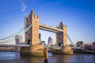 Londra, İngiltere - sabah güneş ışığı kırmızı Çift katlı otobüs ile ikonik Tower Bridge ve arka plan banka bölge