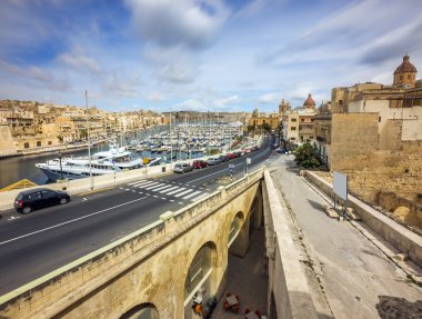 Malta - Birgu Street güneşli bir öğleden sonra mavi gökyüzü ve bulutlar