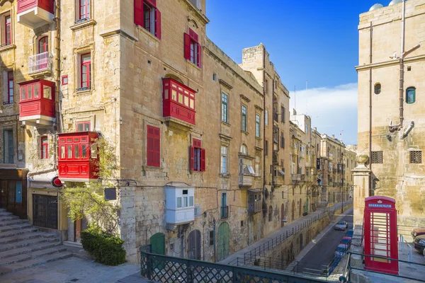 Málta, Valletta - piros telefonfülke és hagyományos piros erkéllyel Valletta, blue sky — Stock Fotó