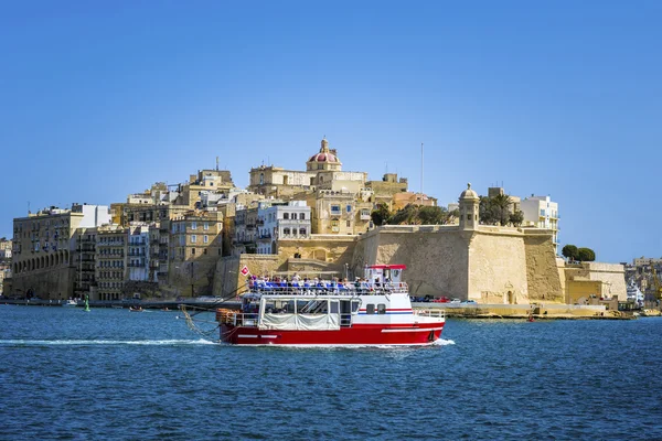 Malta, Valletta - pohled z Gardjola zahrady v Senglea s červenou turistickou lodí ve dne — Stock fotografie