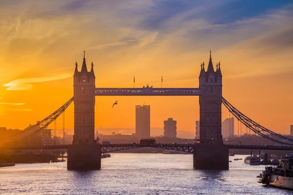 London, England - Silhouette der Tower Bridge bei Sonnenaufgang mit rotem Doppeldeckerbus — Stockfoto