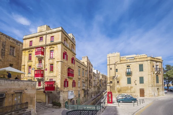 Malta, La Valeta - Antiguos edificios malteses con cabina telefónica roja y balcones rojos tradicionales, ventanas —  Fotos de Stock