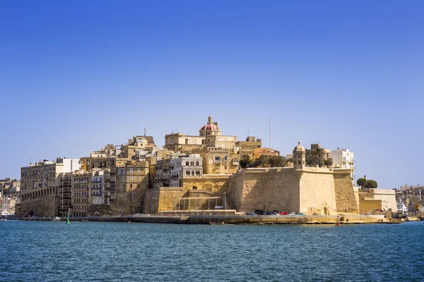 Malta - Las antiguas murallas de Senglea y Gardjola Jardines disparados desde La Valeta en un día soleado con cielo azul claro — Foto de Stock