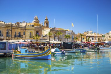 MARSAXLOKK, Malta - renkli, geleneksel Luzzu balıkçı tekneleri Marsaxlokk Market gün güneşli yaz