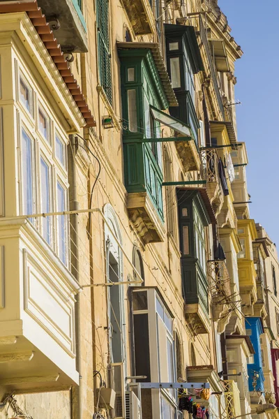 Valletta, Málta - a régi házak és a hagyományos máltai színes erkéllyel Valletta naplementekor — Stock Fotó