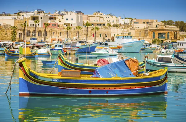 Malta - farbenfrohes traditionelles Luzzu-Fischerboot bei Marsaxlokk an einem sonnigen Sommertag mit grünem Meer und blauem Himmel — Stockfoto