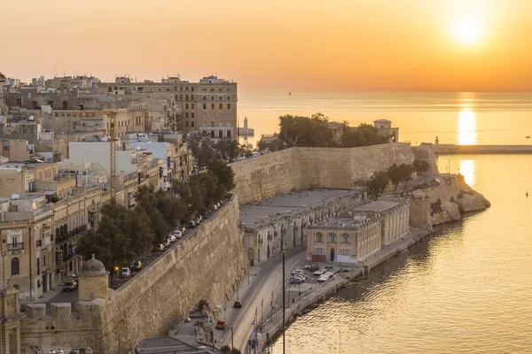 Salida del sol en Malta con la antigua muralla de La Valeta y el Gran Puerto — Foto de Stock