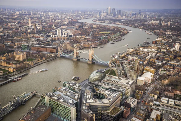 Londres, Inglaterra - Vista aérea de Londres con el mundialmente famoso Tower Bridge, la Torre de Londres y los rascacielos de Canary Wharf en una tarde nublada — Foto de Stock