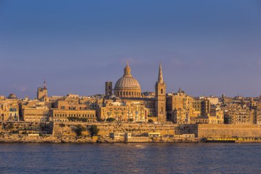 Valletta, Malta - The famous St.Paul's Cathedral and the ancient city of Valletta at sunset with clear blue sky clipart