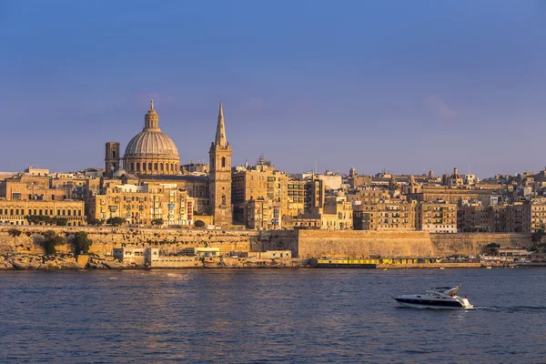 Valletta, Malta - motorový člun a slavné St.Paul katedrála s starobylé město Valletta při západu slunce — Stock fotografie