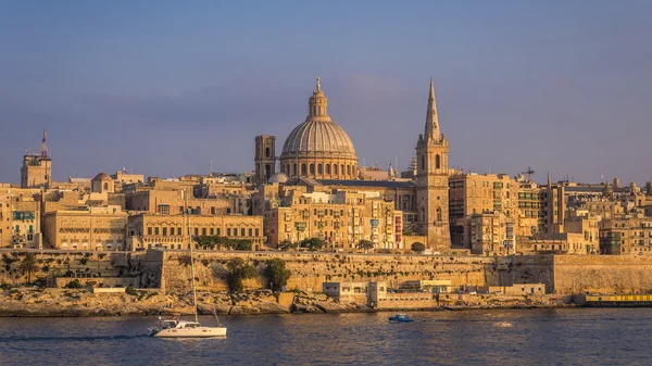 Valletta, Malta - Veleiro e a famosa Catedral de São Paulo com a antiga cidade de Valletta ao pôr-do-sol — Fotografia de Stock