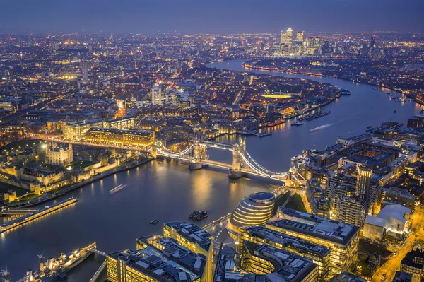 Londres, Inglaterra - Vista aérea del horizonte de Londres. Esta vista incluye la Torre de Londres, el emblemático Tower Bridge, el barco HMS Belfast y los rascacielos de Canary Wharf a la hora azul — Foto de Stock