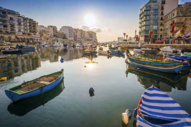 St.Julian'ın, Malta - Spinola Bay geleneksel Malta Luzzu balıkçı tekneleri ile güneş doğarken