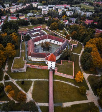 Sarvar, Macaristan - Sarvar Kalesi 'nin (Nadasdy kalesi) sakin bir sonbahar sabahında altın renkli ağaçlar ve yapraklarla hava aracı görüntüsü