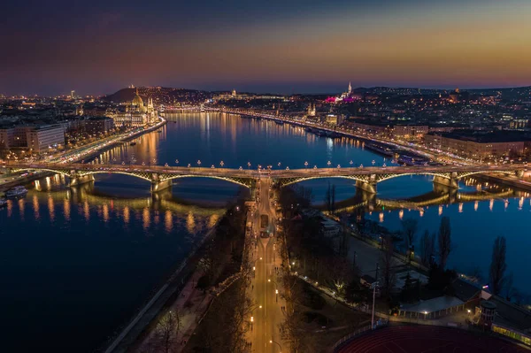 ブダペスト ハンガリー 夕暮れ時に照らされたマーガレット橋の空中スカイラインパノラマビュー ハンガリー議会 Sechenyiチェーンブリッジと澄んだ黄金と青空を背景にブダ城 — ストック写真