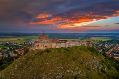 Sumeg, Macaristan - Veszprem ilçesindeki ünlü Sumeg Yüksek Şatosu 'nun günbatımında fırtına bulutları ve bir yaz öğleden sonra arka planda dramatik günbatımı renkleriyle hava panoramik görüntüsü
