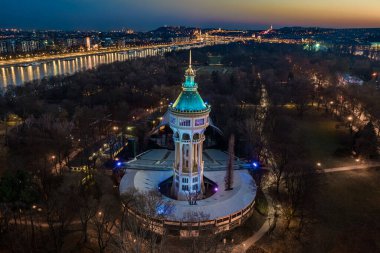 Budapeşte, Macaristan - Margaret Adası Açık Hava Sahnesi 'nin (Margitszigeti Szabadteri Szinpad) açık mavi ve altın gökyüzü ve Budapeşte' nin arka planında yer alan temiz mavi ve altın gökyüzü ile hava kulesi
