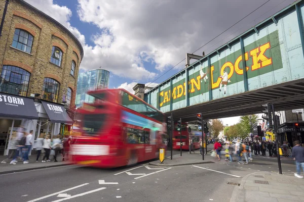 LONDON, UNITED KINGDOM - SEPTEMBER 26, 2015: Camden Lock Bridge and Stables Market, famous alternative culture shops in Camden Town, London, England. Double decker bus goes under the bridge. — Stock Photo, Image