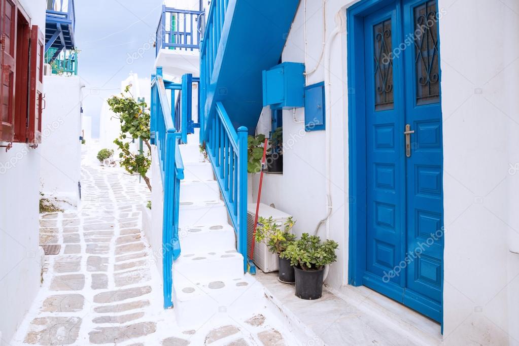 Streetview of Mykonos town with white street and blue door, Greece