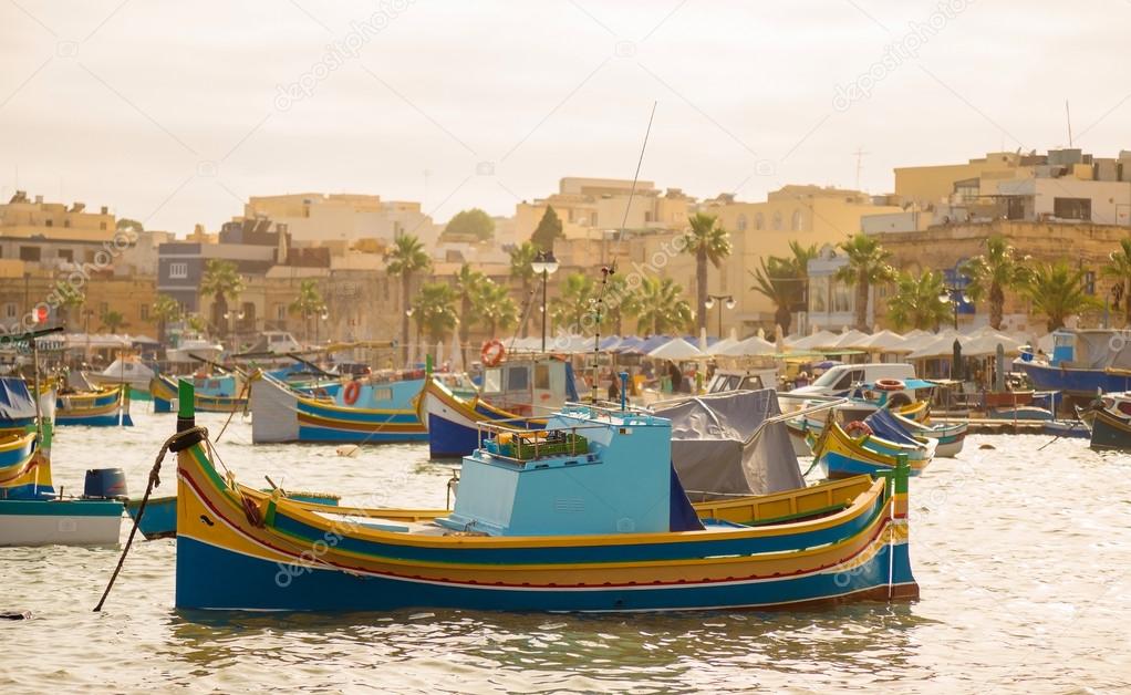 Traditional Luzzu fishing boats at Marsaxlokk Market at morning - Malta