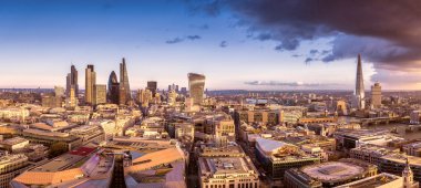Ünlü iş district of London kara bulutlar - Londra, İngiltere ile gün batımında panoramik manzarası