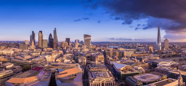 Panorama-Skyline des berühmten Geschäftsviertels von London bei Sonnenuntergang mit dunklen Wolken - london, uk — Stockfoto