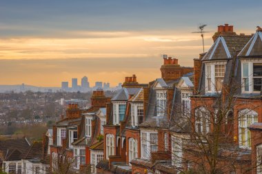 Arka plan, gün doğumu ve Canary Wharf ile bulutlu bir sabahı tipik İngiliz tuğla ev sahipliği yapmaktadır. Panoramic Muswell Hill, Londra, İngiltere'de vurdu