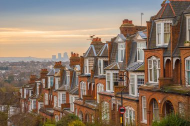 Arka plan, gün doğumu ve Canary Wharf ile bulutlu bir sabahı tipik İngiliz tuğla ev sahipliği yapmaktadır. Panoramic Muswell Hill, Londra, İngiltere'de vurdu