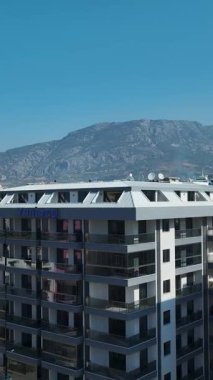 Mavi havuzlar ve bahçelerle çevrili deniz kenarındaki evler.