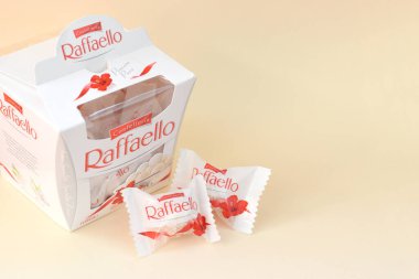 KHARKOV, UKRAINE - 26 Mart 2020: Bej arkaplanda Raffaello şekerlemeleri. Raffaello, İtalyan imalatçı Ferrero 'nun 1990 yılında pazara getirdiği küresel bir hindistan cevizi badem şekerlemesi.