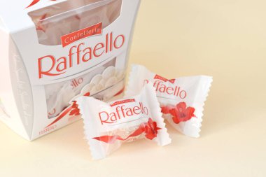 KHARKOV, UKRAINE - 26 Mart 2020: Bej arkaplanda Raffaello şekerlemeleri. Raffaello, İtalyan imalatçı Ferrero 'nun 1990 yılında pazara getirdiği küresel bir hindistan cevizi badem şekerlemesi.