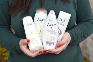 KHARKOV, UKRAINE - 16 Ekim 2020: genç kız Dove ürünleri bulundurur. 1955 yılında İngiliz pazarına giren Dove, şu anda Unilever 'a ait olan ve 80' den fazla ülkede satılan bir kişisel bakım markası.