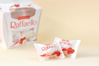 KHARKOV, UKRAINE - 26 Mart 2020: Bej arkaplanda Raffaello şekerlemeleri. Raffaello, İtalyan imalatçı Ferrero 'nun 1990 yılında pazara getirdiği küresel bir hindistan cevizi badem şekerlemesi.