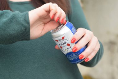 KHARKOV, UKRAINE - 16 Ekim 2020: Genç kız açık havada 1664 Kronenbourg Blanc bira kutusu tutuyor. 1664 Blanc, Fransız bira fabrikası Kronenbourg 'dan dünya çapında ihraç edilen buğday birasıdır.