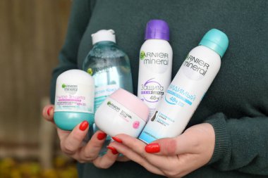 KHARKOV, UKRAINE - 16 Ekim 2020: Genç kız Garnier ürünlerini elinde tutuyor. Garnier, Fransız kozmetik şirketi L 'Oreal' in bir kitle pazarı kozmetik markası.