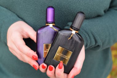 KHARKOV, UKRAINE - 16 Ekim 2020: Kız, Tom Ford kadife orkide ve siyah orkide parfüm şişelerini tutuyor. Tom Ford, Amerikalı moda tasarımcısı. 2006 'da ünlü lüks markasını kurdu.