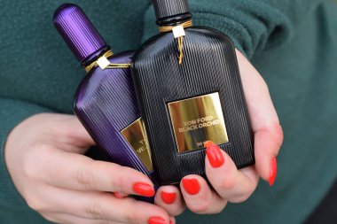 KHARKOV, UKRAINE - 16 Ekim 2020: Kız, Tom Ford kadife orkide ve siyah orkide parfüm şişelerini tutuyor. Tom Ford, Amerikalı moda tasarımcısı. 2006 'da ünlü lüks markasını kurdu.