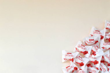 KHARKOV, UKRAINE - 26 Mart 2020: Bej arkaplanda Raffaello şekerlemeleri. Raffaello, İtalyan imalatçı Ferrero 'nun 1990 yılında pazara getirdiği küresel bir hindistan cevizi badem şekerlemesi.